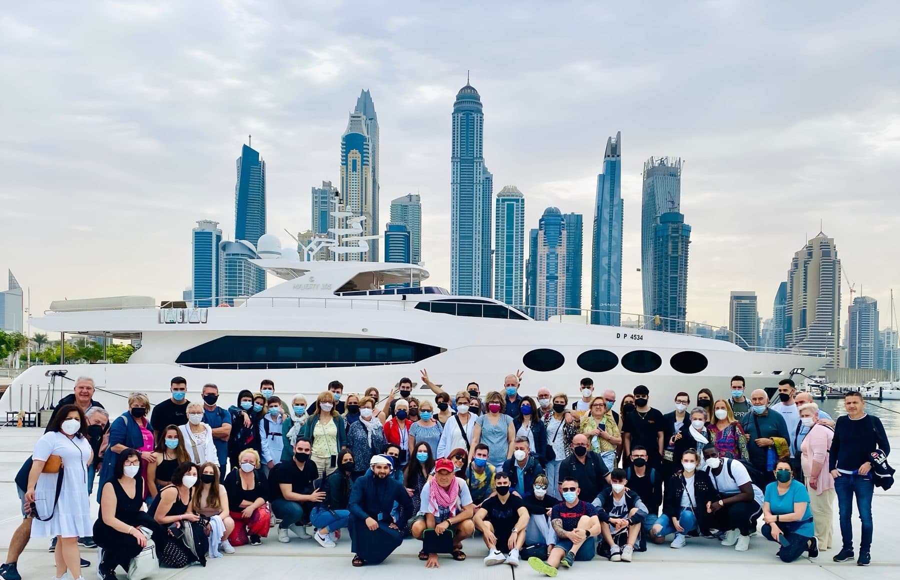 Guests by a yacht with the Dubai Marina skyline